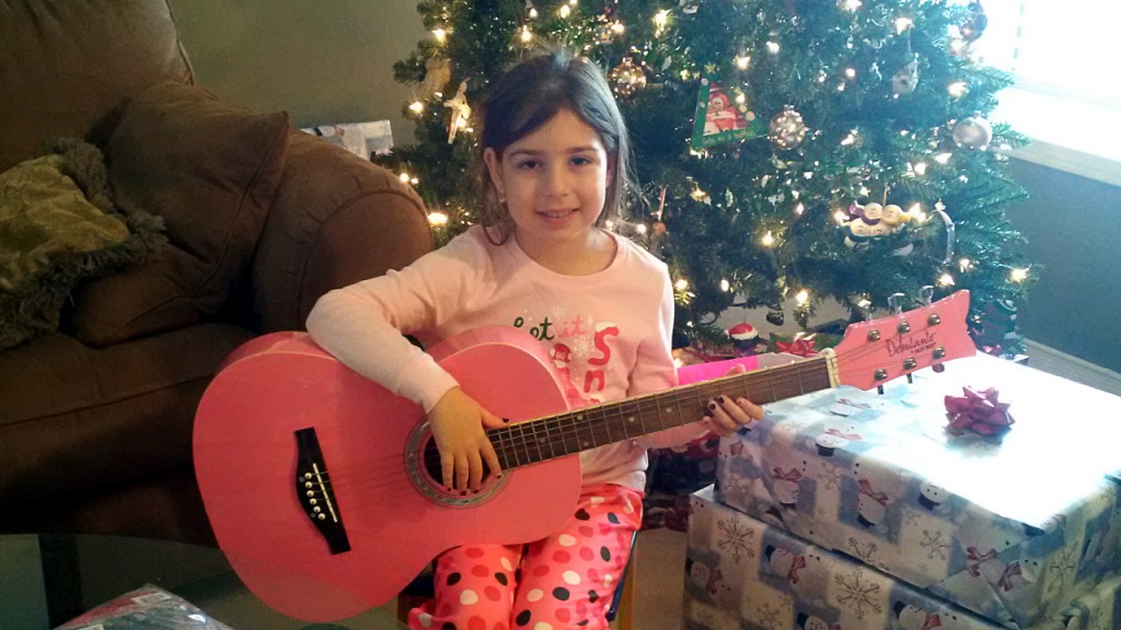 My daughter opening her first guitar on Christmas (yes, it had to be pink)...